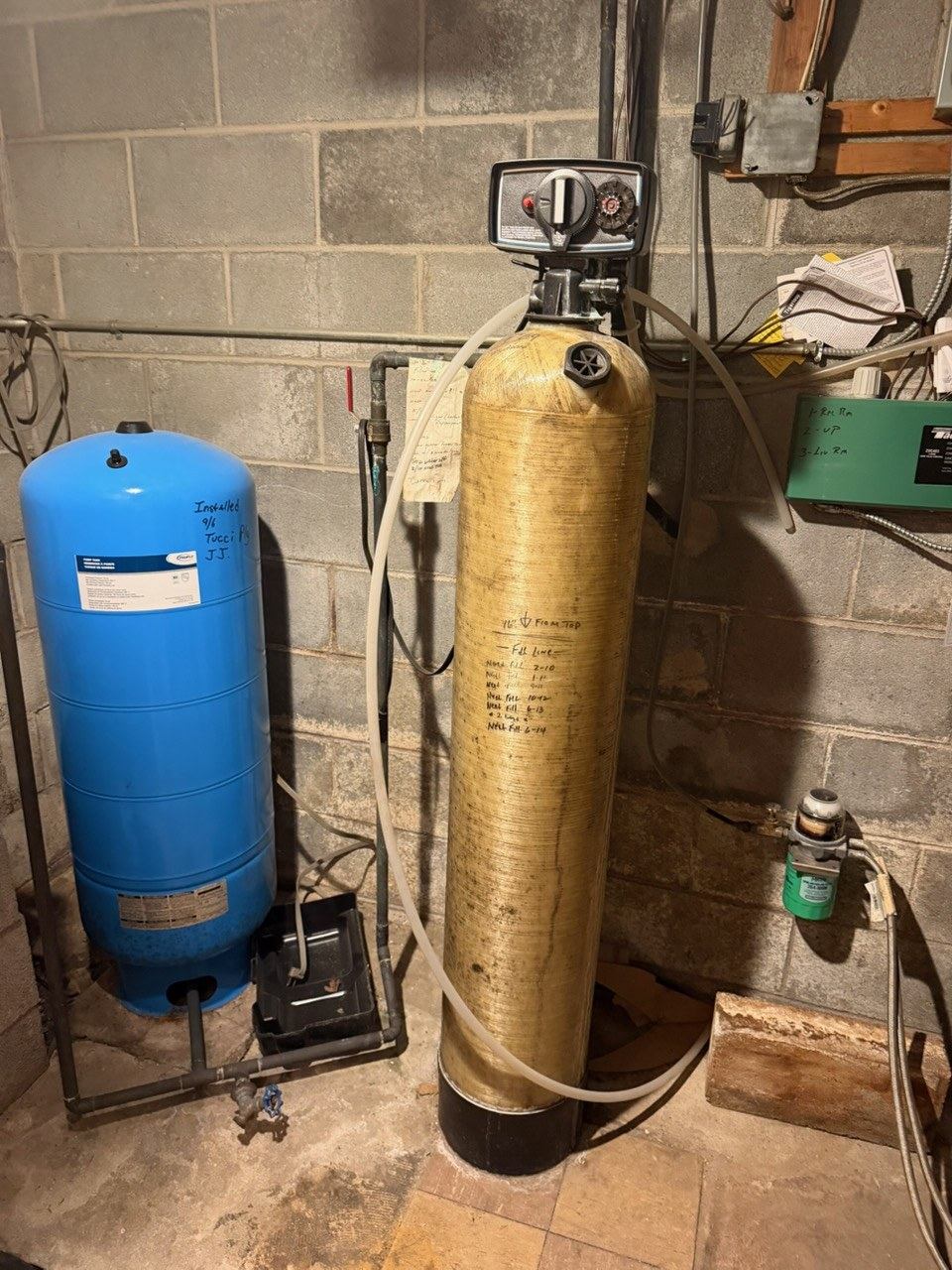 An older water treatment tank in a basement, showing years of service