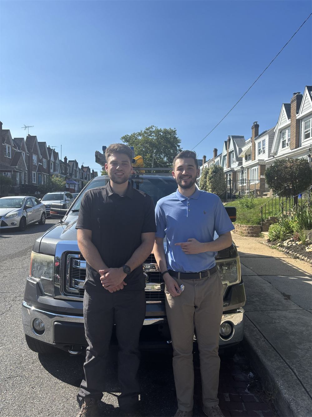 Ryan and Robert, co-owners of Gridline Water Systems, standing in front of their service truck